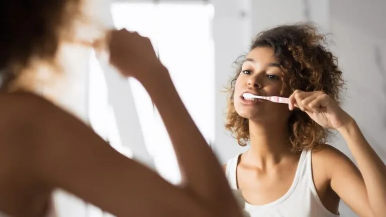afro woman brushing teeth in bathroom panorama 2021 08 27 09 40 38 utc 1